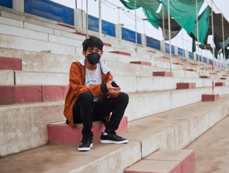 Andre, 14, sits in the stands of a repurposed sports stadium in Carabayllo, a district in the north of Lima, Peru, while he waits for his scheduled appointment at the UNICEF-supported Community Mental Health Center that occupies one of the buildings. 