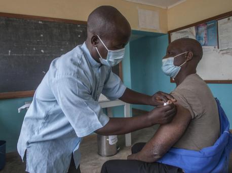 Senior Disease Control Surveillance Assistant Andrew Mbingwani gives Gibson Chikhasu Zulu, a teacher at Chikande Community Day Secondary School, his second dose of COVID-19 vaccine at Chikande Health Center in Malawi's Ntcheu District on June 17, 2021. 