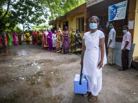 Nilam Bamaniya, a 23-year-old general nursing midwife, holds a vaccine carrier filled with vaccine doses for a COVID-19 vaccination session at a UNICEF-supported public health center in Samlaya, Vadodra, Gujarat, India on July 20. 2021. 
