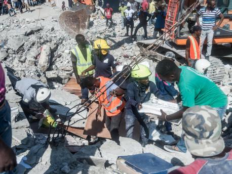 People look for survivors in the rubble in the neighborhood of Dexia 6, Les Cayes, Haiti on August 15, 2021, after a 7.2-magnitude earthquake struck Haiti's southwest peninsula.