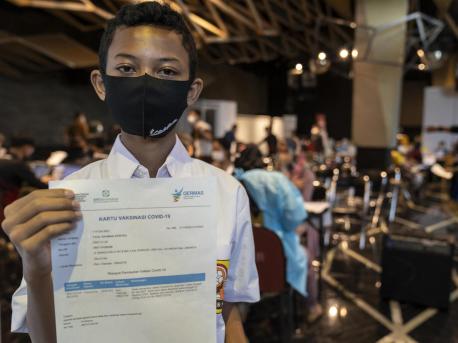 Fazil, 14, shows his certificate after receiving his second dose of COVID-19 vaccine at the Cilandak Town Square Mall in South Jakarta, Indonesia, on August 24, 2021.