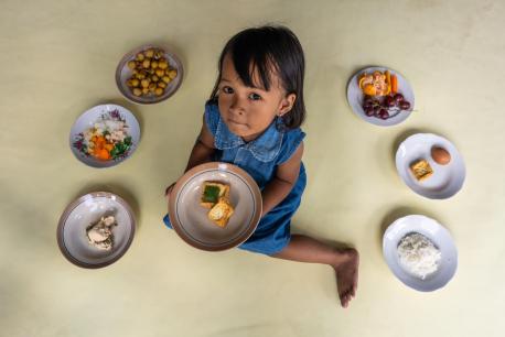 Gelsi, 3, daughter of Lisa Kurniasari, holds a plate of tofu at her home in Paseban Village, Klaten, Central Java Province, Indonesia, on 8 September 2021