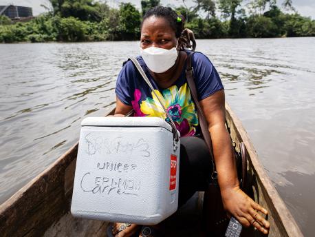 Health workers take a boat across the St. John river in Liberia to vaccinate children against polio.