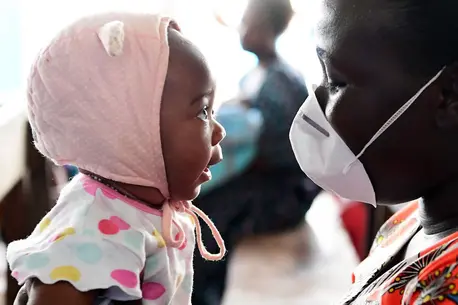 Man with Mask Holding Baby