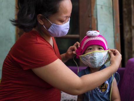 On June 14, 2020, a mother puts a mask on her 3-year-old daughter, Fatima, before leaving their home in Bekasi, West Java province, Indonesia. 