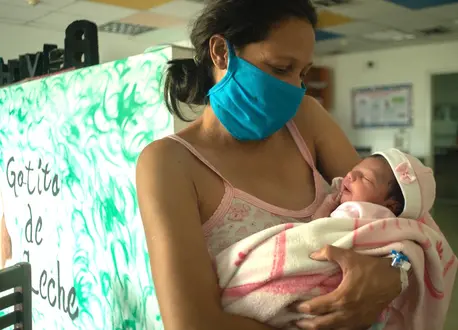 A new mother holds her baby, sleepy and full of breast milk, at a UNICEF-supported breastfeeding workshop at a health center in Caracas, Venezuela. A new mother holds her baby, sleepy and full of breast milk, at a UNICEF-supported breastfeeding workshop at a health center in Caracas, Venezuela.