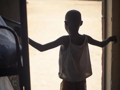 An 8-year-old girl rescued from female genital mutilation stands in a doorway at Kalas Girls Primary School in Uganda's Amudat District. An 8-year-old girl rescued from female genital mutilation stands in a doorway at Kalas Girls Primary School in Uganda's Amudat District.