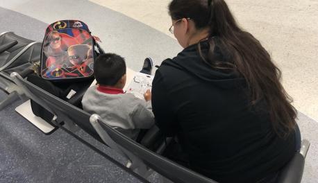Olivia Pena, deputy program director for the Young Center, sits with a migrant child who got separated from his parents at the U.S. border.
