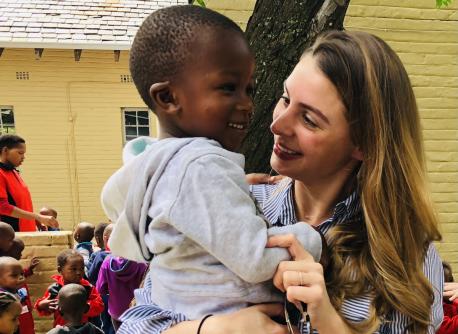 UNICEF Next Generation Global Principal Emily Watts Johnson bonds with a child during a program visit with UNICEF in 2021.
