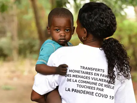 In October 2020, an agent holds a boy while registering vulnerable families in Moro, a suburb of Kinshasa, Democratic Republic of Congo. In October 2020, an agent holds a boy while registering vulnerable families in Moro, a suburb of Kinshasa, Democratic Republic of Congo.
