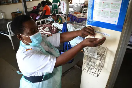 The in-charge nurse at Fort Portal Regional Referral Hospital in Uganda sanitizes her hands after attending to patients in the pediatric ward. The in-charge nurse at Fort Portal Regional Referral Hospital in Uganda sanitizes her hands after attending to patients in the pediatric ward.