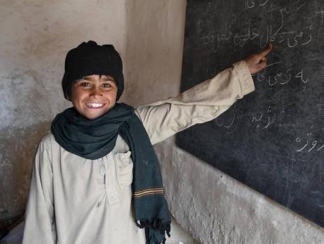 A young student points to a blackboard at a UNICEF-supported community-based education center in Kandahar city, Afghanistan.