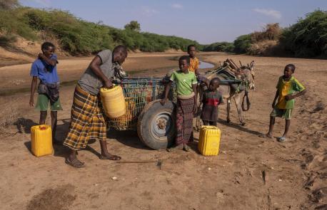 In Somalia, Ibrahim, second from left, collects what little water he can from a dried up riverbed with help from his young sons and a nephew. 
