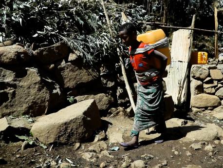 Zufan, 10, of Ethiopia, carrying a heavy jug of water back from the community tap, a daily chore that keeps her out of school.