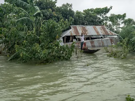 A family travels by boat after flash floods inundated northeastern Bangladesh in May and June 2022. A family travels by boat after flash floods inundated northeastern Bangladesh in May and June 2022.