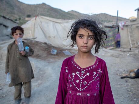 On June 24, 2022, 8-year-old Nasrin stands outside the tent where she is living with her family in Gayan District, Paktika Province, Afghanistan. 