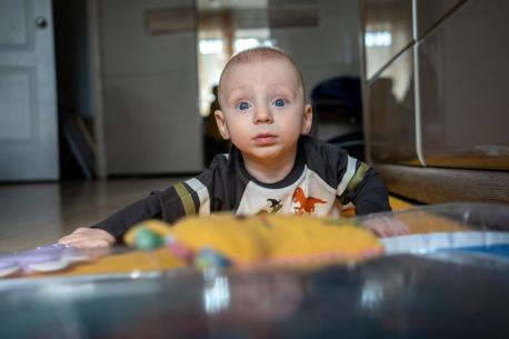 Six-month-old Yehor of Ukraine looks up while crawling.
