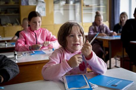 Children sit at desks in a classroom of their school in the village of Olyzarivka, Ukraine.
