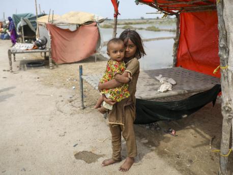 On Sept.2, 2022, six-year-old Vaidya holds her baby sister Nera beside the temporary shelter where she and her family are living in Mirpur Khas District, Sindh Province, Pakistan. 