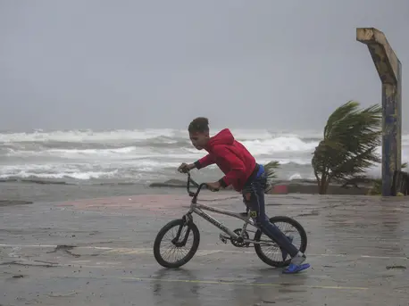 A youth rides his bike in Nagua, Dominican Republic, on Sept. 19, 2022, as Hurricane Fiona passes through the country. A youth rides his bike in Nagua, Dominican Republic, on Sept. 19, 2022, as Hurricane Fiona passes through the country.