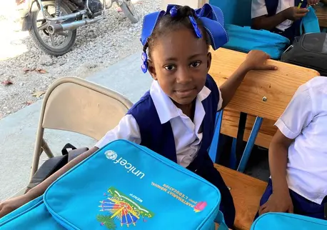A young student in Haiti with UNICEF-provided school supplies distributed after the 2021 earthquake to ensure kids could keep learning. A young student in Haiti with UNICEF-provided school supplies distributed after the 2021 earthquake to ensure kids could keep learning.