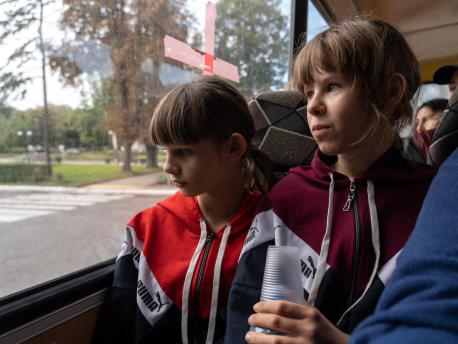 Sisters Anya, 10, left, and Polina, 11, evacuate their home in eastern Ukraine with their mother and siblings.