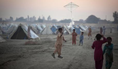 A boy flies a kite at a camp for families displaced by flooding in Sindh Province, Pakistan.