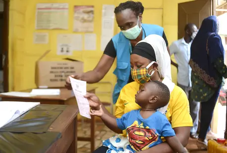 Margaret Gwada of UNICEF Ghana assists a mother who has just received a birth certificate for her child at the Births and Deaths Registry in Tamale. Margaret Gwada of UNICEF Ghana assists a mother who has just received a birth certificate for her child at the Births and Deaths Registry in Tamale.