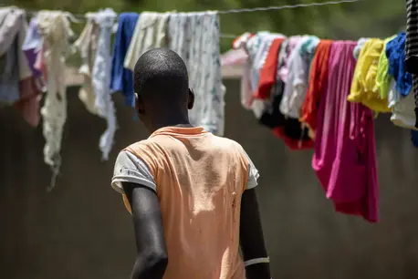 An adolescent girl looks at laundry hanging on clotheslines, her back turned to the camera An adolescent girl looks at laundry hanging on clotheslines, her back turned to the camera