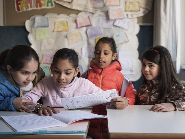 Nine-year-old Syrian refugee Badiaa (second left) sits at a desk with Italian and Syrian friends in her classroom at a public elementary school in Trento, Trentino province, Italy, Tuesday 2 May 2017. Badiaa, who is originally from Homs, Syria, arrived from Lebanon through a UNICEF-supported humanitarian corridor that helped 93 Syrian refugees reach Italy safely in February 2016.