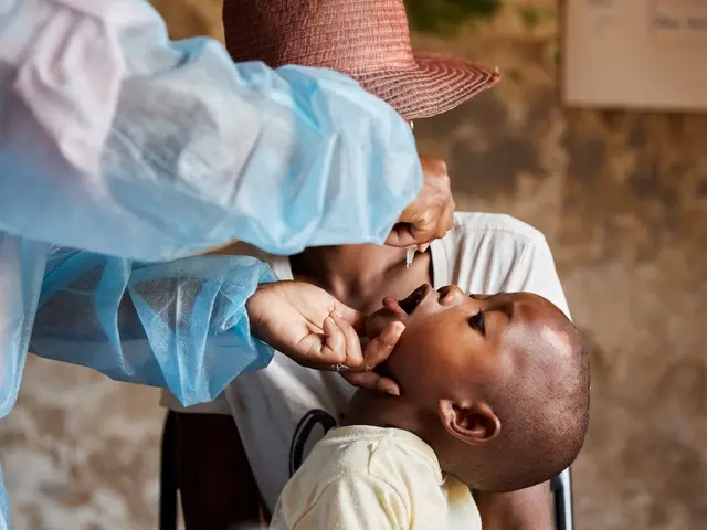 A health care worker administers the polio vaccine to a young child.