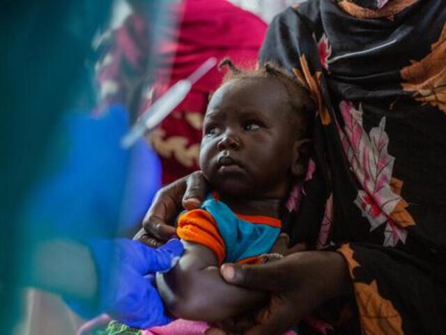Small child being held by her mother.