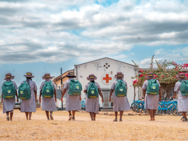 Female Village Health Workers with backpacks and backs turned to camera in Zimbabwe
