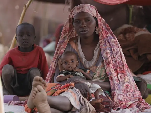 A mother holds her baby son in a temporary shelter in Tawila, North Darfur, Sudan on April 15, 2025. 