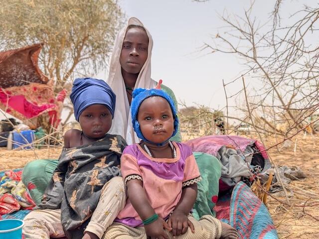 A mother and her two children at the temporary refugee relocation site in Tiné, Chad, near the border with Sudan.