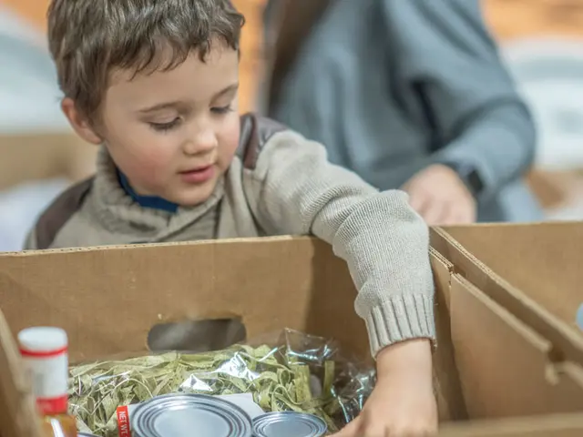 Young child at a food bank reaching into a box of food