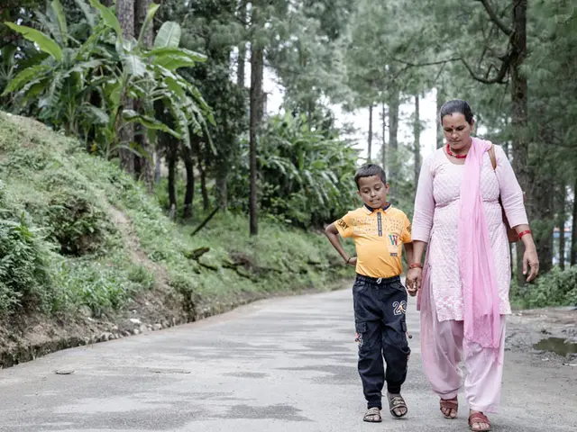 Mother and son holding hands walking through a wooded area