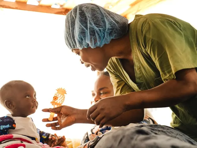 A UNICEF-supported psychosocial worker entertains a baby at an Ebola treatment center in Bunia, Ituri Province, Democratic Republic of Congo.