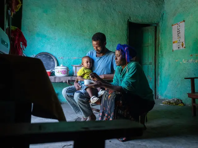 A mother and father at home in Ethiopia with their infant child.