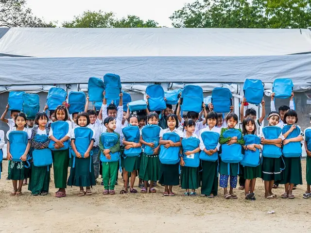 Children hold UNICEF backpacks outside a school tent at BEHS Pyitharyar in Pyawbwe Township, Mandalay Region, Myanmar.