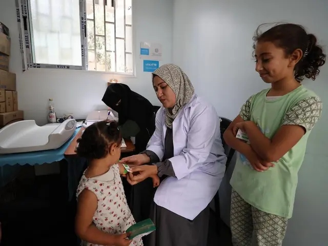 A health worker screens a child for malnutrition at a UNICEF-supported health center in Khan Younis, Gaza Strip. 