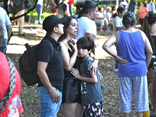 Families wait anxiously in a park in Cali after evacuating their homes following a major earthquake in Colombia. 