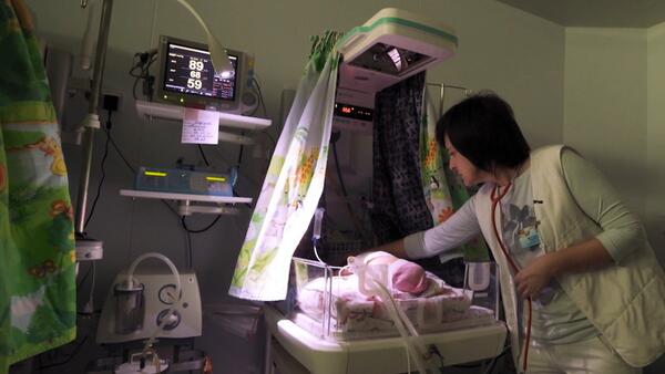 Dr Iryna Kondratova tends to a newborn in a patient care room