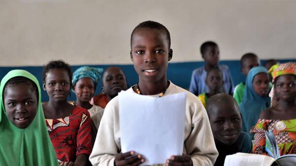 Gilbert, a 14-old Nigerian refugee living in Cameroon, holds a letter he wrote in reply to the question, "What does education mean to you?" 