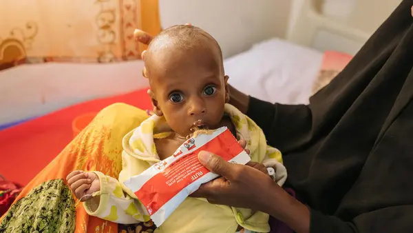 A malnourished 6-month-old is fed Ready-to-Use Therapeutic Food by his mother at UNICEF-supported Garowe General Hospital Stabilization Center in Puntland, Somalia, on Oct. 27, 2022.