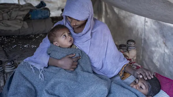 A mother keeps her children warm inside her tent after receiving a winter kit from UNICEF in the village of Zangi Brohy, Dadu District, Sindh Province, Pakistan. 