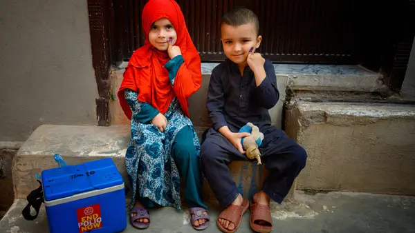 A brother and sister in Rawalpindi, Pakistan, show their fingers marked with ink indicating they have received the polio vaccine.