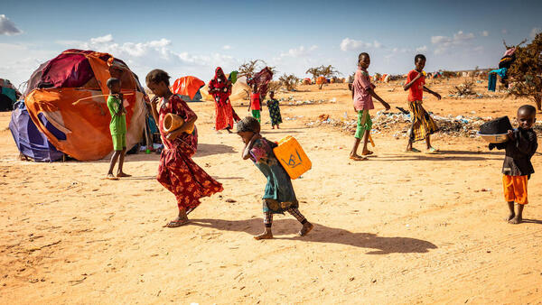 Children carry water at the Qurdubey camp in Dollow, Somalia, where UNICEF is providing humanitarian aid to families displaced by severe drought in the Horn of Africa, one of the world's worst climate change-related disasters.