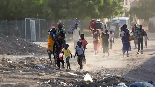On April 19, 2023, people flee their neighborhoods amid fighting between the army and paramilitaries in Khartoum, Sudan.