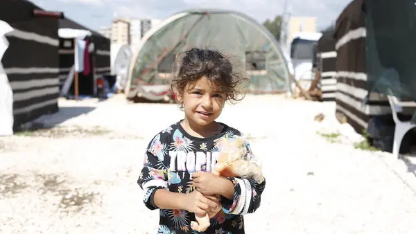 A little girl holds her toy at a temporary shelter in Hatay, Türkiye on May 1, 2023, after two devastating earthquakes hit southeast Türkiye.